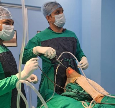 Surgeons performing a minimally invasive foot surgery using specialized equipment, led by Dr. Ishwar Meena, foot and ankle specialist.