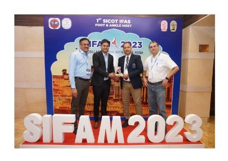 Dr. Ishwar Meena receiving an award at the 1st SICOT IFAS Foot & Ankle Meet 2023, standing with colleagues in front of the SIFAM 2023 banner.